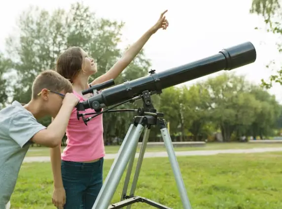 2 enfants utilisant un télescope