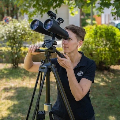 Image d'une personne regardant à travers des jumelles Celestron Skymaster 15x70