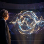 Homme âgé en costume regardant une projection holographique d'ondes énergétiques dorées et bleues, évoquant la physique quantique.