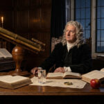 Isaac Newton, en perruque, assis à son bureau éclairé à la bougie. Il est entouré d'instruments scientifiques et de livres, face à une fenêtre donnant sur un ciel nocturne étoilé.